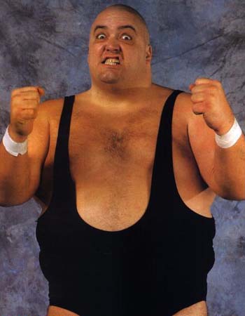 1991 Ford Bronco - A wrestler poses with a fierce look and clenched fists against a textured background.
