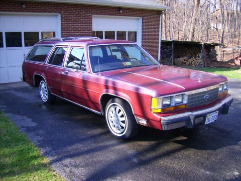 1982 Ford LTD Crown Victoria - This station wagon is parked in front of a brick garage on a sunny day.
