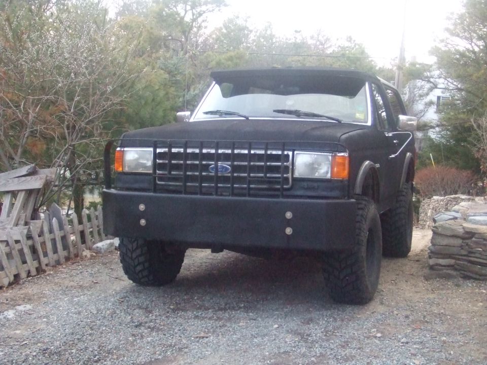 Black Ford Bronco II with aftermarket bumper and grille. Lifted suspension and off-road tires