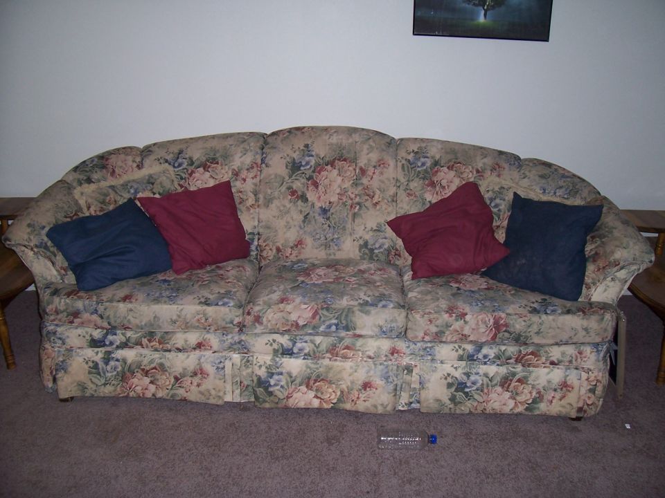 Floral couch with blue and red pillows
