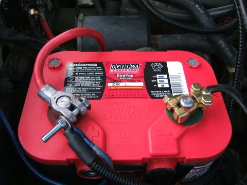1991 Ford Bronco - Close-up of a red Optima RedTop battery with its terminals and cables connected.