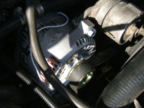 1991 Ford Bronco - Close-up view of a vehicle's alternator and drive belt system.