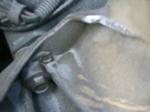 1991 Ford Bronco - A close-up view of a vehicle's engine component, showing a bolt and some wiring.