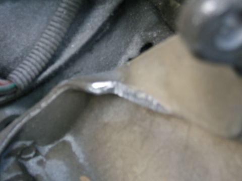 1991 Ford Bronco - Close-up view of engine bay components, including a wiring harness and a metal bracket.