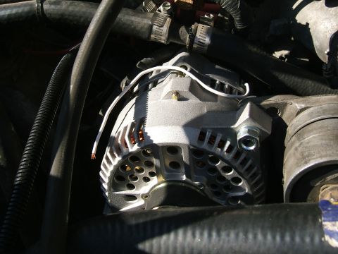 1991 Ford Bronco - Engine alternator detail, showing electrical connections and cooling vents.