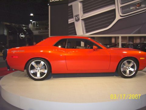 1979 Ford Bronco - Side view of an orange Dodge Challenger on display at an auto show.