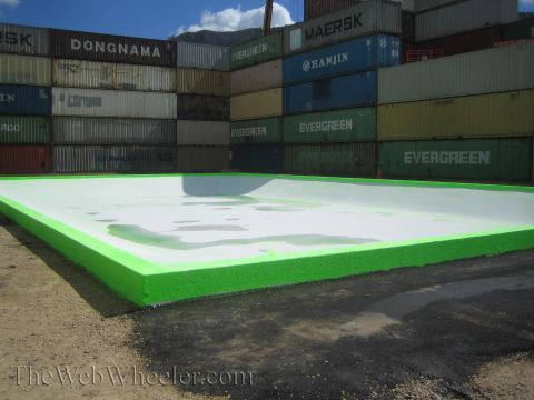 1990 Ford Bronco - Large green-bordered concrete pad set before a wall of stacked Maersk, Hanjin and Evergreen shipping containers.