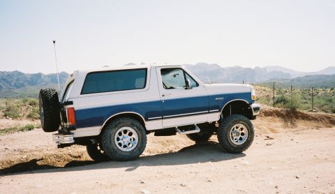 1996 Ford Bronco - This two-tone Ford Bronco is seen from a three-quarter front angle on a dusty, arid landscape.
