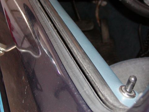 1988 Ford Bronco - This photo shows a close-up of a worn door seal and lock pin inside a vehicle.
