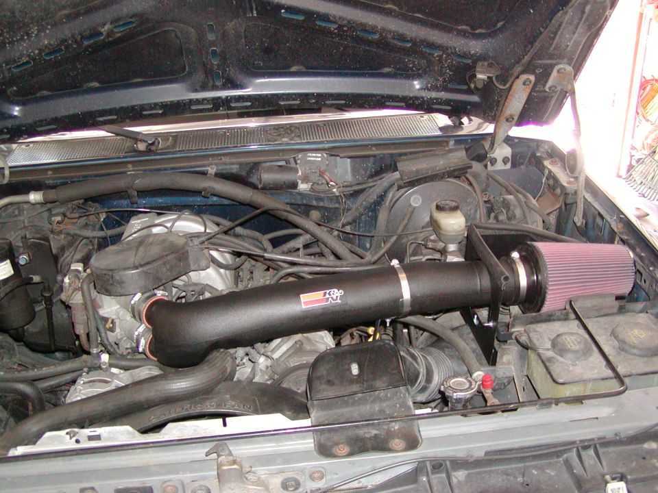 Installed cold air intake with red cone filter under an open hood