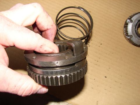 1996 Ford Bronco - Close-up of a manual locking hub component being held by a hand, with a spring and another gear visible.
