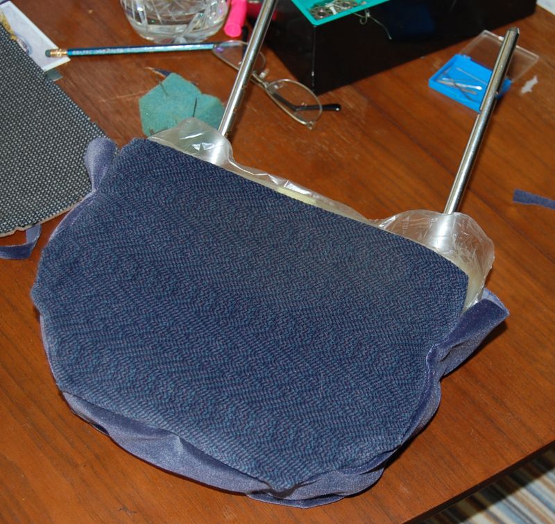 Blue fabric car headrest with chrome posts on a wooden table