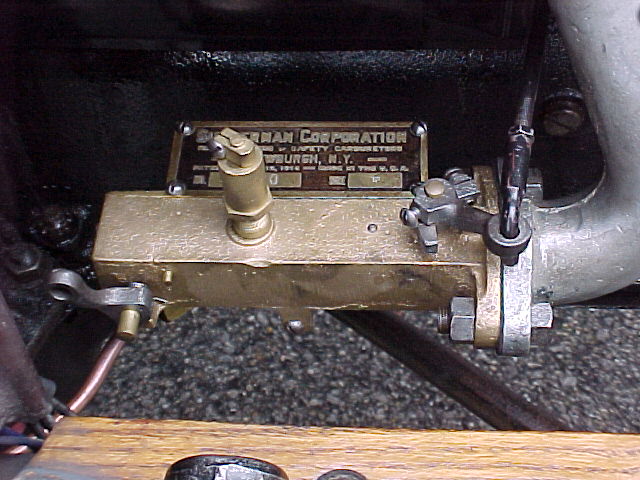 Brass carburetor with manufacturer plate on a 1913 Ford Model T engine