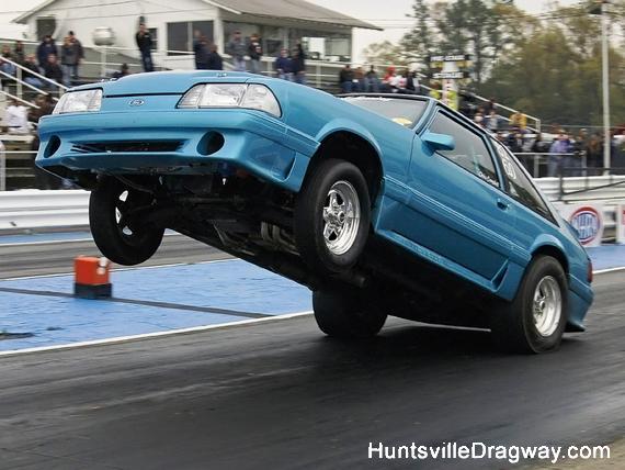 Blue Fox body Mustang drag car doing a wheelie on a drag strip. HuntsvilleDragway.com watermark