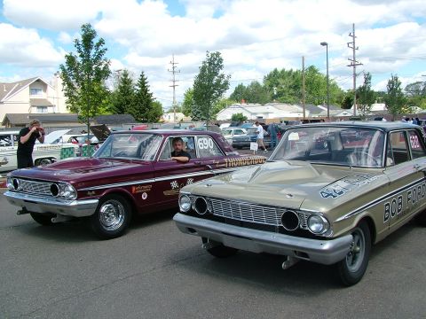 1972 Ford Ranchero - Two classic Ford sedans are parked side-by-side at an outdoor event, with spectators in the background.