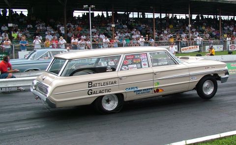 1972 Ford Ranchero - A Ford station wagon, possibly a Galaxie, competes in a drag race with spectators in the stands.