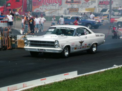 1972 Ford Ranchero - A white 1966 drag racing car with numerous decals and a prominent hood scoop is captured on the track, with other vehicles and spectators i…