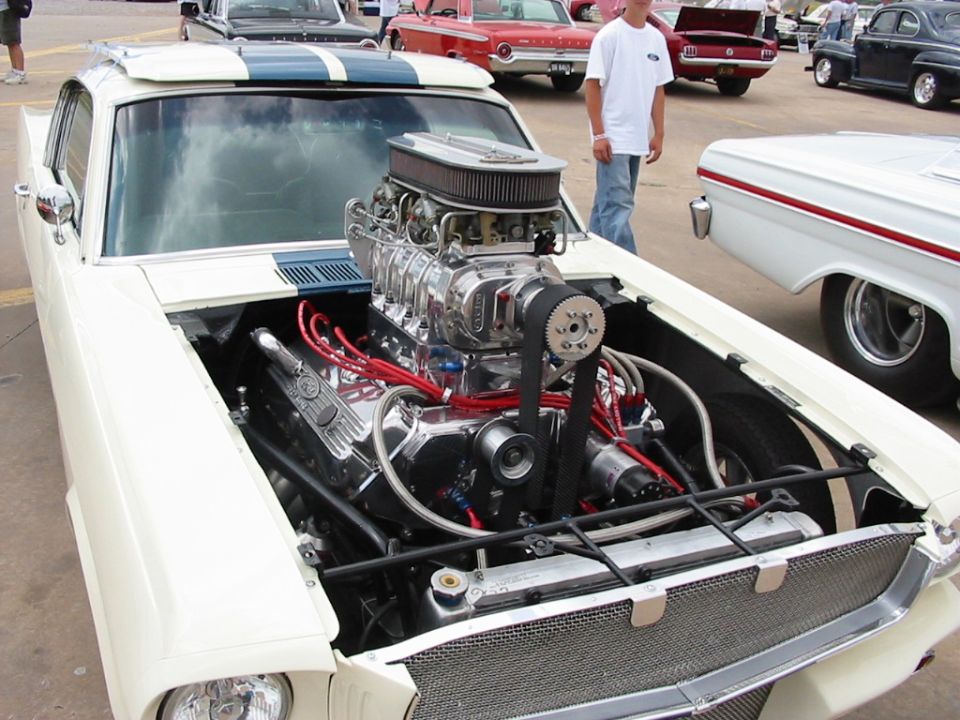 White 1972 Ford Ranchero with exposed supercharged V8 engine and blue racing stripes