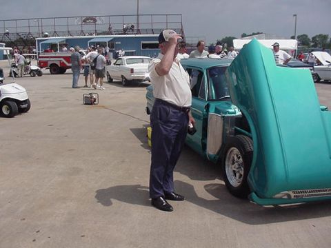 1972 Ford Ranchero - A man stands next to a teal pickup truck with its hood open at an outdoor event.