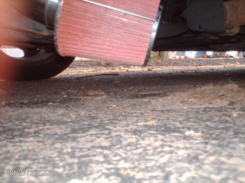 1996 Ford Probe - A red air intake filter is visible on the underside of a vehicle, with other cars in the background.