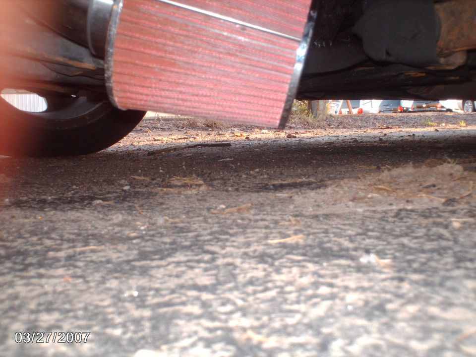 Red air intake filter attached to exhaust pipe, viewed from below