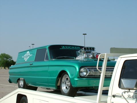 1972 Ford Ranchero - Customized panel van with a prominent supercharger and KICKER branding is loaded onto a trailer.