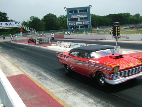 1972 Ford Ranchero - A modified 1957 Ford Fairlane 500 with flame graphics races down a drag strip.