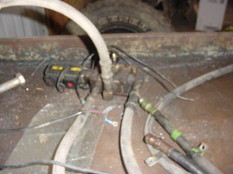 1992 Ford Bronco - Close-up view of a winch mechanism, hoses, and wiring, with a tire visible in the background.