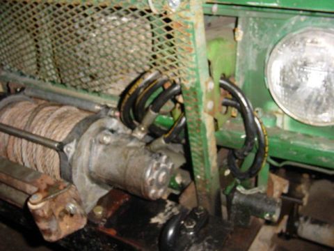 1992 Ford Bronco - Close-up of a winch and headlight assembly on a green vehicle.