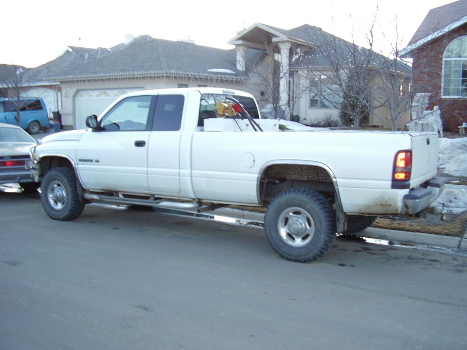 White 2001 Dodge 2500 pickup truck, side view, with a fuel tank and pump in the bed
