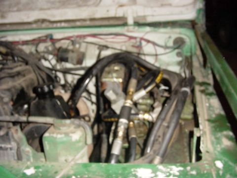 1992 Ford Bronco - The engine bay is filled with a complex network of hoses and wiring, obscuring most of the engine components.