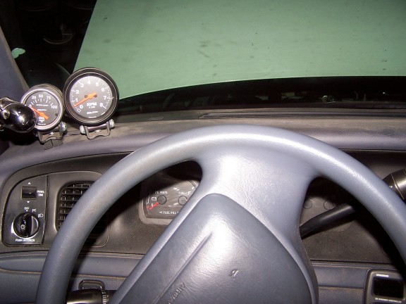 Dashboard with steering wheel, tachometer, and oil pressure gauge. Fuel gauge visible in dash