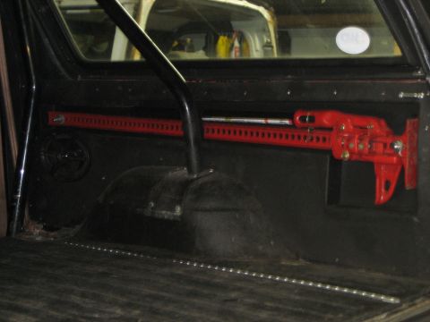 1990 Ford Bronco - A red hi-lift jack is mounted inside a vehicle's interior.