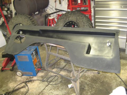 1990 Ford Bronco - A black vehicle interior panel, possibly a door or fender liner, is shown disassembled and resting on a metal stand.