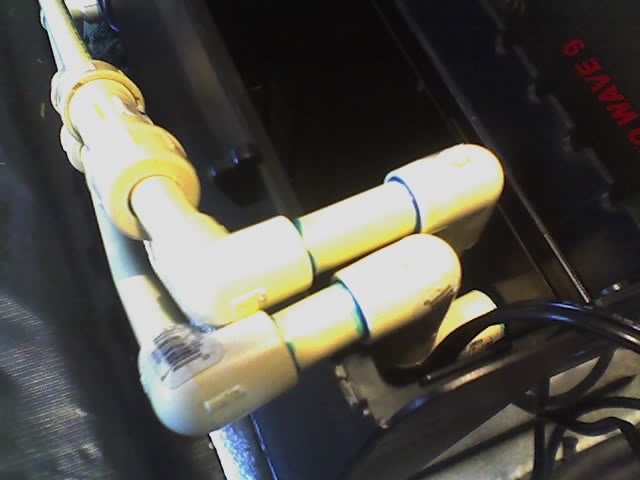 Yellow spark plug wire boots routed along a dark valve cover in an engine bay