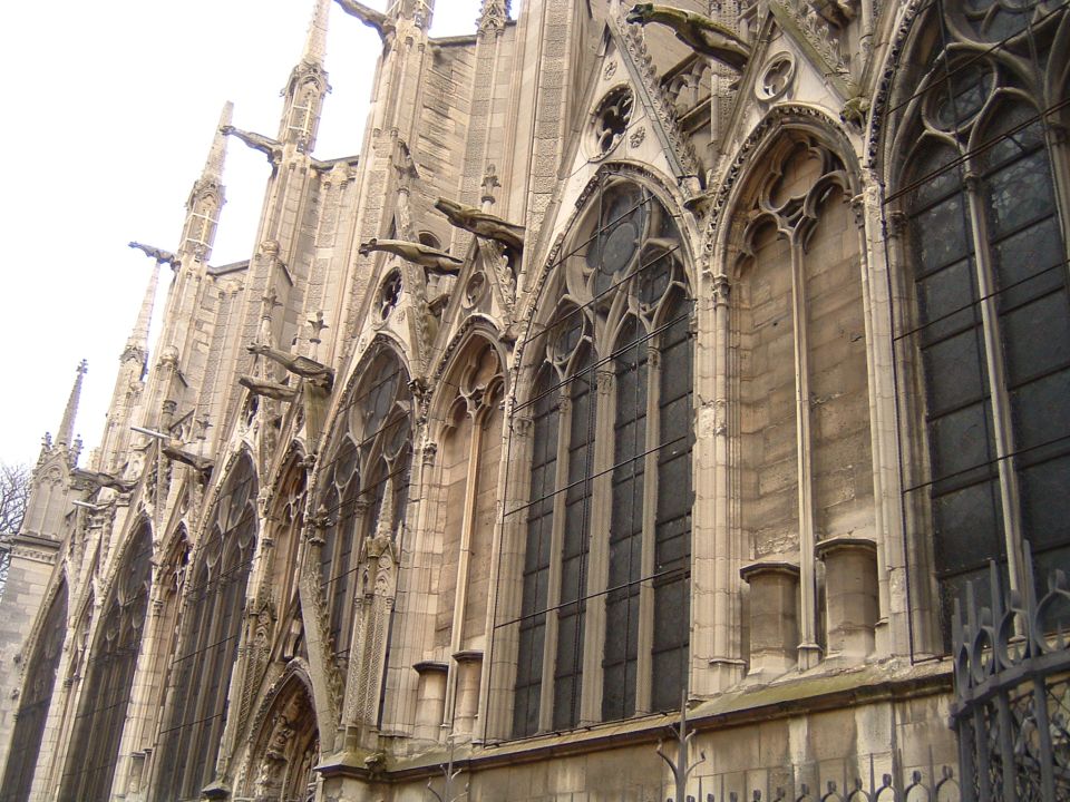Gothic cathedral facade with gargoyles and arched windows, right side view