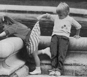 1976 Ford F-150 - Two children are engaged in play near a textured concrete barrier, with a prominent website watermark in the lower portion of the image.