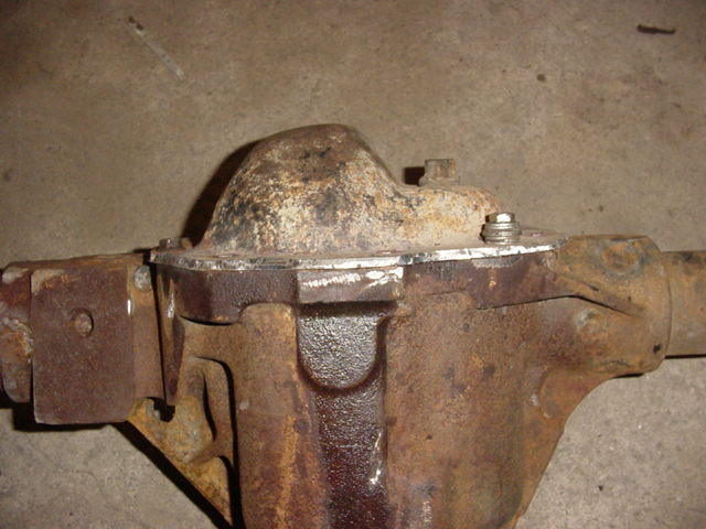 Rusty differential housing and axle center section on a concrete floor