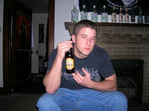 1996 Ford Bronco - A man sits indoors holding a bottle of beer in front of a brick fireplace.