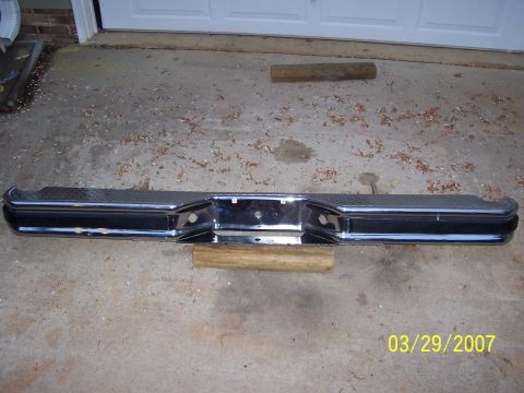 1988 Ford Bronco - A chrome rear bumper with diamond plate texture is shown, resting on wooden blocks.