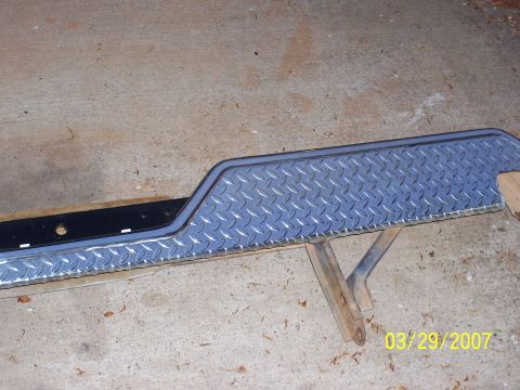 1988 Ford Bronco - Diamond plate bumper step with black mounting bracket is shown on a concrete floor.