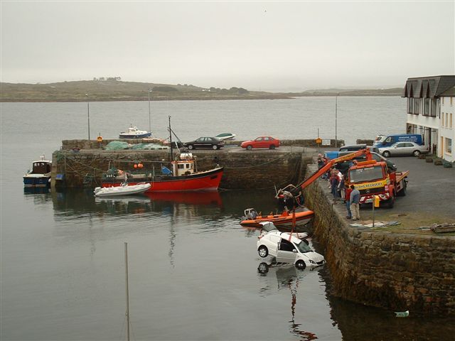 tow truck lifting white van out of harbor water