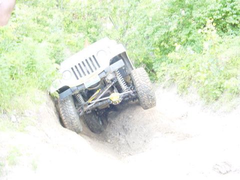 1992 Ford Bronco - Off-road Jeep Wrangler TJ navigating a challenging dirt hill climb.