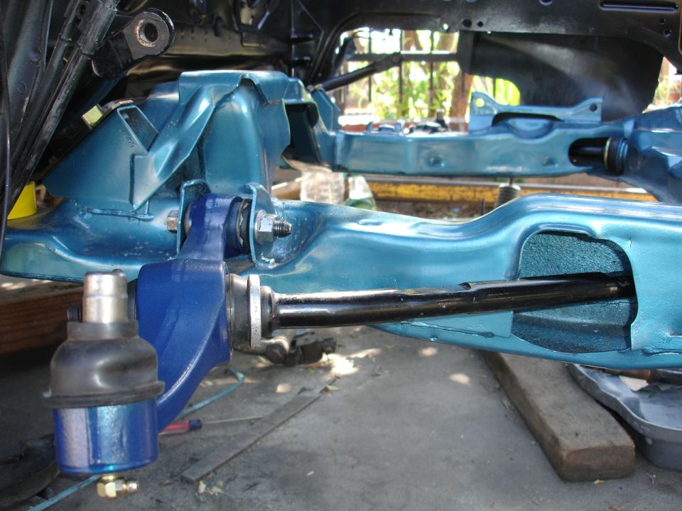 Close-up of a car's front suspension system, painted teal and blue