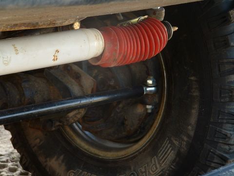 1978 Ford Bronco - A detailed view of a vehicle's suspension system and tire, showing mechanical components.