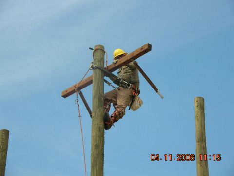 1991 Ford F-150 - Lineman working on a utility pole against a clear blue sky. Photo timestamped 04.11.2006.