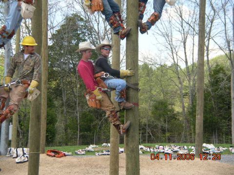 1991 Ford F-150 - Workers ascend utility poles during training or a job, with equipment laid out below.
