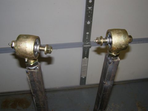 1993 Ford Bronco - Close-up view of two custom suspension control arms, likely for off-road modification.