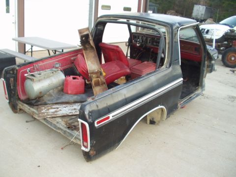 1993 Ford Bronco - This disassembled Ford F-Series truck is missing its front end and has items stored in the bed.