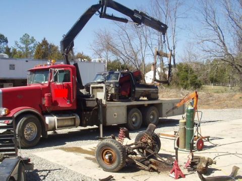 1993 Ford Bronco - A 1993 Ford Bronco is being loaded onto a flatbed truck by a crane.